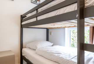 Modern bunk bed in a bright room with wood flooring and art at Schaelsbergerbosch - Garden House &.