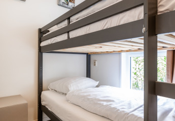 Litera moderna en una habitación luminosa con suelo de madera y arte en Schaelsbergerbosch - Garden House &.