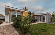 Moderne Lodge mit großer Fensterfront und Terrasse im Grünen bei Ravenbosch, mit Kamin und Whirlpool.