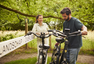 Due persone con biciclette si godono una giornata in un alloggio glamping immerso nel verde.