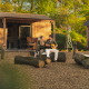 Par hygger sig udenfor naturhus 'Barn' ved Campsite Si-Es-An i Holland omgivet af træ og natur.
