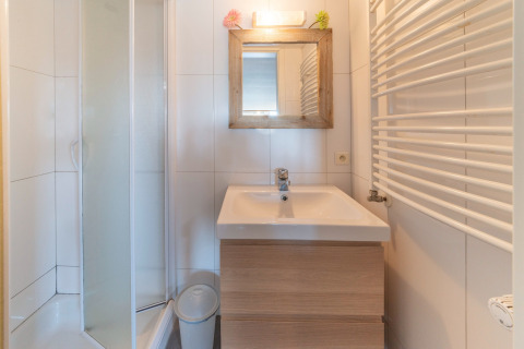 Modernes Bad im Le Chalet sous les Hetres in Belgien mit Dusche, Waschbecken und Holzspiegel.