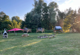 Glampinglocatie met verhoogde tentplatforms, vuurplaats en picknicktafels in Dachzelt Dorf Sandstedt, Nedersaksen.
