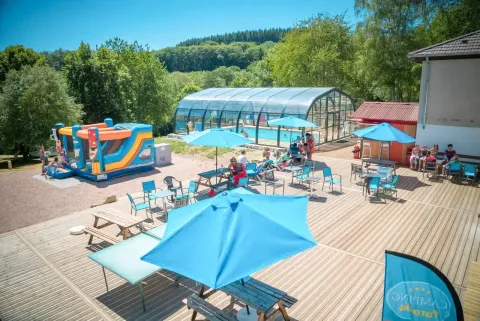 Udendørsområde på Camping Paradis Les Chanterelles i Auvergne-Rhône-Alpes med pool, parasoller og aktiviteter.