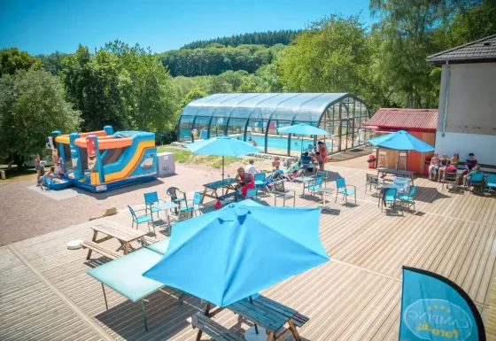 Udendørsområde på Camping Paradis Les Chanterelles i Auvergne-Rhône-Alpes med pool, parasoller og aktiviteter.