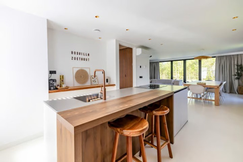 Moderne, lichte keuken en eetruimte met grote ramen in Forest villa Zoethout, De Kremmer, Nederland.