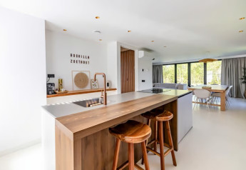 Cucina e zona pranzo moderne e luminose con grandi finestre nella Forest villa Zoethout, De Kremmer, Paesi Bassi.
