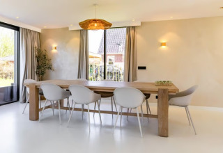 Eetkamer in Forest villa «Zoethout» bij De Kremmer, Nederland, met houten tafel en witte stoelen.