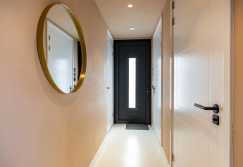 Corridoio moderno con grande specchio rotondo, porte bianche e porta nera in Forest villa «Zoethout», De Kremmer, Paesi Bassi.