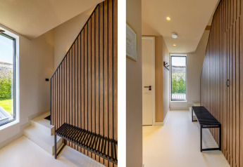 Recibidor luminoso con escalera y banco modernos en Forest villa «Zoethout» en De Kremmer, Países Bajos.