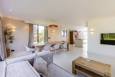 Lichte, moderne woonkamer in Forest villa «Zoethout», De Kremmer, Nederland, met eettafel en bank.