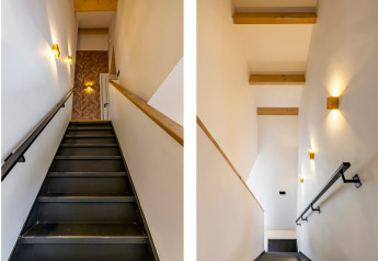 Due viste di una scala moderna alla Forest villa Zoethout, De Kremmer, Paesi Bassi, con travi in legno.