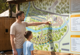 Un uomo e un ragazzo osservano una mappa vicino alla Safari Tent a Hameau de l'Ourthe, Belgio.