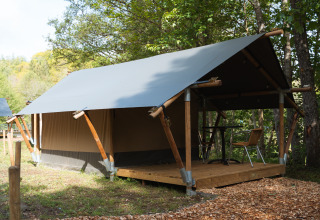 Tenda safari presso Hameau de l'Ourthe in Belgio, circondata da alberi verdi e natura tranquilla.