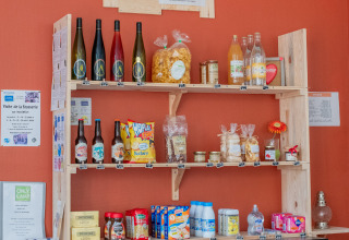 Regal mit regionalen Speisen und Getränken in der Rezeption von Onlycamp Camping l'Orée d'Alsace, Grand Est, Frankreich.