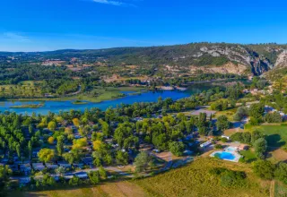 Luftfoto af Seasonova Camping Les Prés du Verdon med flod, bjerge og pool i Provence-Alpes-Côte d’Azur, Frankrig.