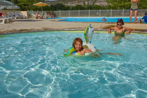 Kinderen en volwassenen genieten van het zwembad bij Seasonova Camping Les Prés du Verdon in Provence, Frankrijk.