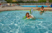 Children and adults enjoying the pool at Seasonova Camping Les Prés du Verdon in Provence, France.