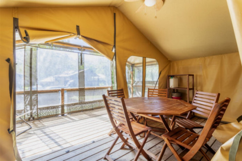 Binnenaanzicht van de Comfort Lodge safaritent bij Seasonova Camping Les Prés du Verdon met houten meubels.