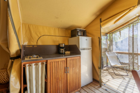 Wohnküche eines Comfort Lodge Safari-Zeltes mit Kühlschrank und Terrasse auf dem Seasonova Camping Les Prés du Verdon.