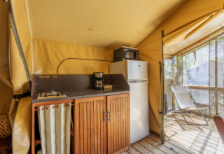 Keuken in een Comfort Lodge safaritent met koelkast en terras bij Seasonova Camping Les Prés du Verdon in Frankrijk.