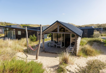 Außenansicht der Adventure Lodge in Bloemendaal aan Zee, Niederlande, umgeben von Dünenlandschaft.