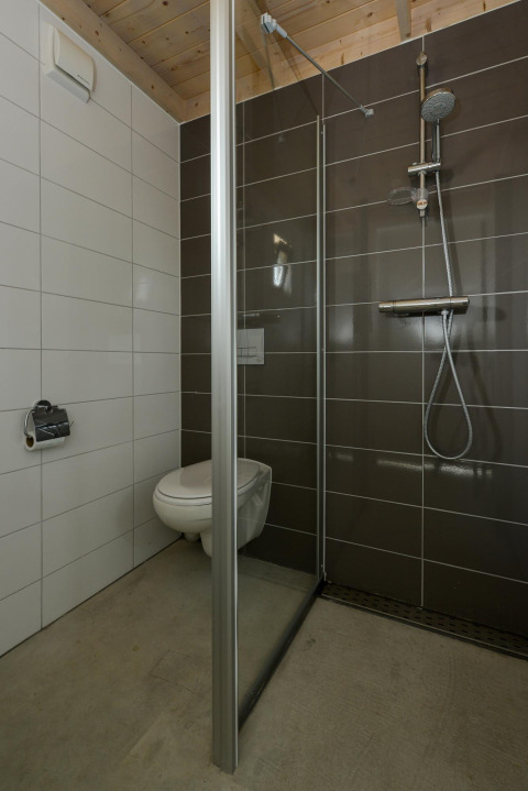 Bagno moderno all’Adventure Lodge, Bloemendaal aan Zee, con WC sospeso e cabina doccia.