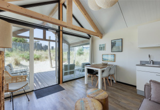 Interno luminoso e moderno dell’Adventure Lodge a Bloemendaal aan Zee, Paesi Bassi, con vista sulle dune.