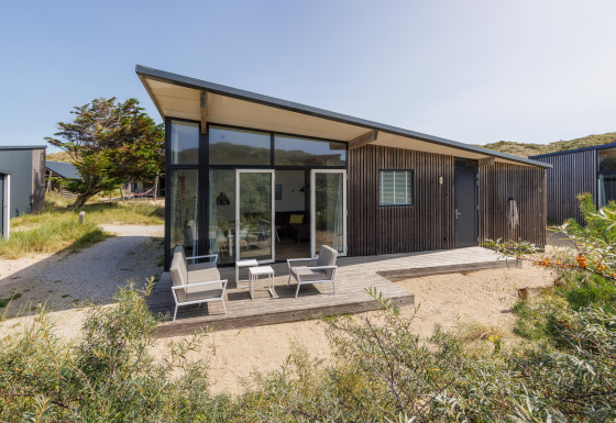 Moderno lodge Sea House Comfort a Bloemendaal aan Zee, Paesi Bassi, con veranda e sedie all’aperto.