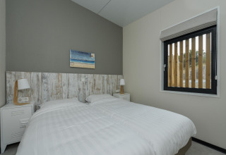 Chambre moderne avec deux lits simples et du linge blanc à Sea House Comfort, Bloemendaal aan Zee, Pays-Bas.