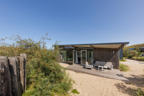 Moderno Sea House Royal lodge a Bloemendaal aan Zee, Paesi Bassi, con patio e sabbia tutto intorno.
