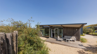 Moderno Sea House Royal lodge a Bloemendaal aan Zee, Paesi Bassi, con patio e sabbia tutto intorno.