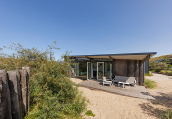 Modern Sea House Royal lodge at Bloemendaal aan Zee, Netherlands, with patio and sandy surroundings.