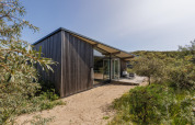 Moderno Sea House Royal lodge a Bloemendaal aan Zee, Paesi Bassi, circondato da dune e vegetazione.