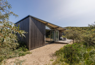 Lodge moderne Sea House Royal à Bloemendaal aan Zee, Pays-Bas, entouré de dunes de sable et verdure.