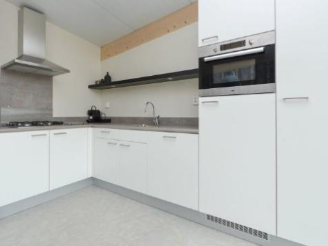 Cucina moderna con mobili bianchi e forno a incasso al Sea House Royal, Bloemendaal aan Zee, Paesi Bassi.