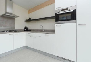 Cuisine moderne avec des armoires blanches et un four encastré à Sea House Royal, Bloemendaal aan Zee, Pays-Bas.
