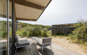 Patio in legno con sedute moderne alla lodge Sea House Royal, Bloemendaal aan Zee, Paesi Bassi, tra le dune.