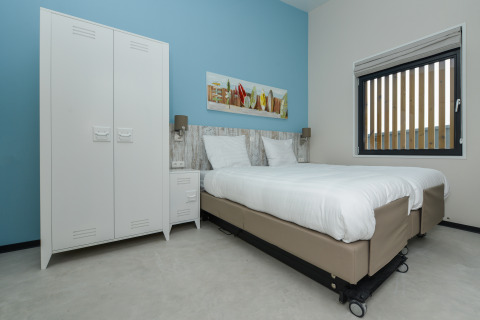 Chambre contemporaine avec lits jumeaux, linge blanc, placard et tableau au Sea House Special.