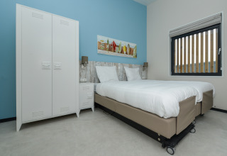 Chambre contemporaine avec lits jumeaux, linge blanc, placard et tableau au Sea House Special.