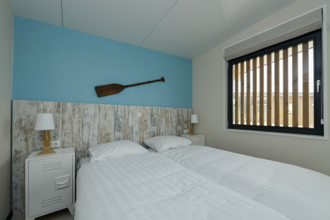 Camera da letto al Sea House Special Lodge a Bloemendaal aan Zee, con due letti singoli e una pagaia decorativa.