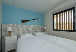 Chambre du lodge Sea House Special à Bloemendaal aan Zee avec deux lits simples et une décoration de rame.