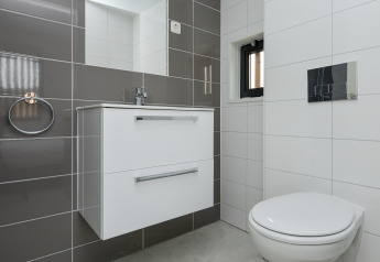 Salle de bains moderne avec équipements blancs et carrelage gris au Sea House Special, Bloemendaal aan Zee.