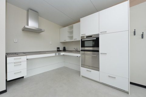 Cucina bianca moderna al Sea House Special, Bloemendaal aan Zee, Paesi Bassi, con elettrodomestici integrati.