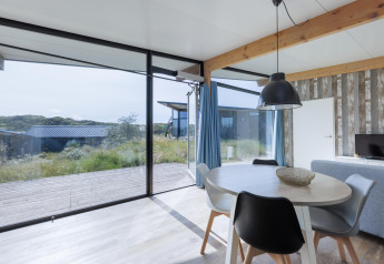 Lys stue med store vinduer i Sea House Special, Bloemendaal aan Zee, Holland med udsigt over naturen.