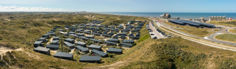 Panoramafoto af ferieparken Bloemendaal aan Zee med hytter, klitter og havudsigt i Nordholland, Nederlandene.