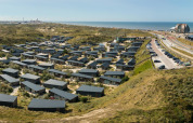 Panoramic photo of Bloemendaal aan Zee holiday park with cottages, dunes, and sea view in North Holland, Netherlands.