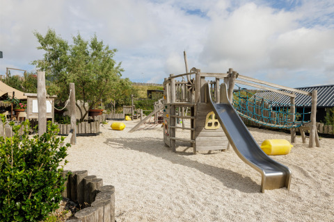 Legeplads med træklatrestativ og rutsjebane i feriepark Bloemendaal aan Zee, Nordholland, Holland.