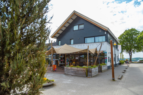 Foto van Treelodge boomhut op Gulperberg in Nederland, met terras en schaduwdoeken buiten.