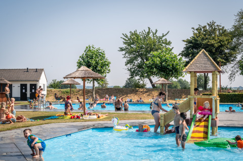 Kinderen spelen in het buitenzwembad bij Treelodge, Gulperberg in Nederland op een zonnige dag.
